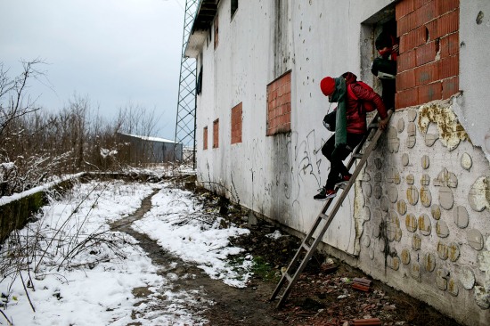 Afghan refugees exit an abandoned building.