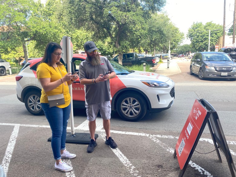 Bob, a Pearl Ambassador, helps Carolyn Bresinger pay for parking using her phone at the Pearl Saturday. The website appeared to be malfunctioning making it difficult for some visitors to complete the payment.