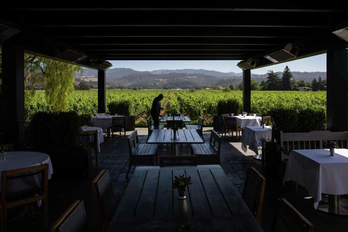 Anani Lawson sets a table at the Heitz Cellar in Napa, Calif., on Wednesday, Jun 22, 2022.