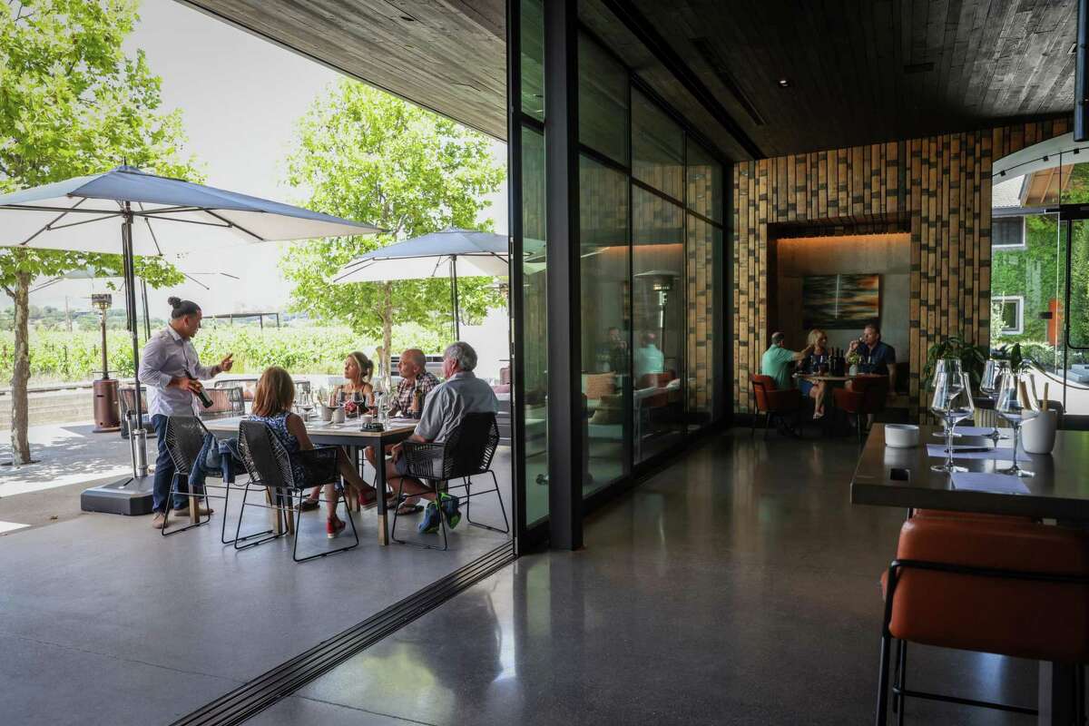 Visitors sit in the newly renovated wine tasting room at Clos Du Val in Napa, Calif. on Thursday, June 23, 2022. The winery added the new tasting room in 2018 and is among several beloved and citric wineries to undergo rebrands and remodeling.
