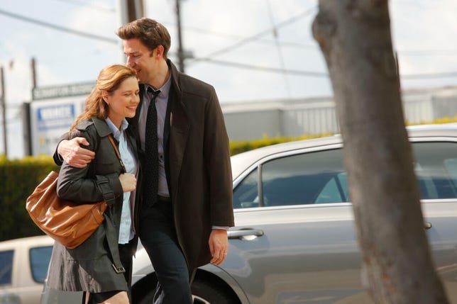 Jim and Pam walk arm in arm in The Office